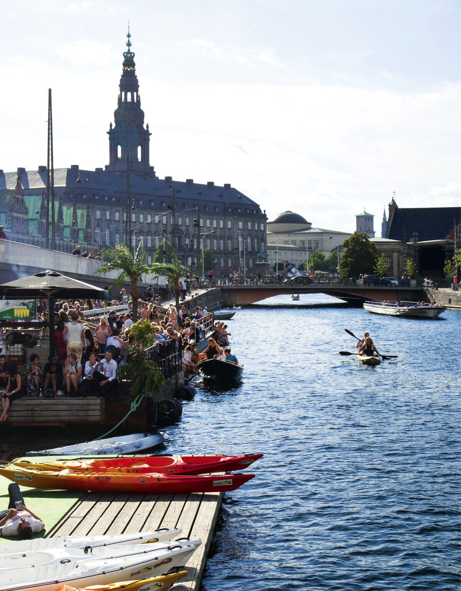 En gruppe mennesker hygger sig ved kanalen ved Christiansborg