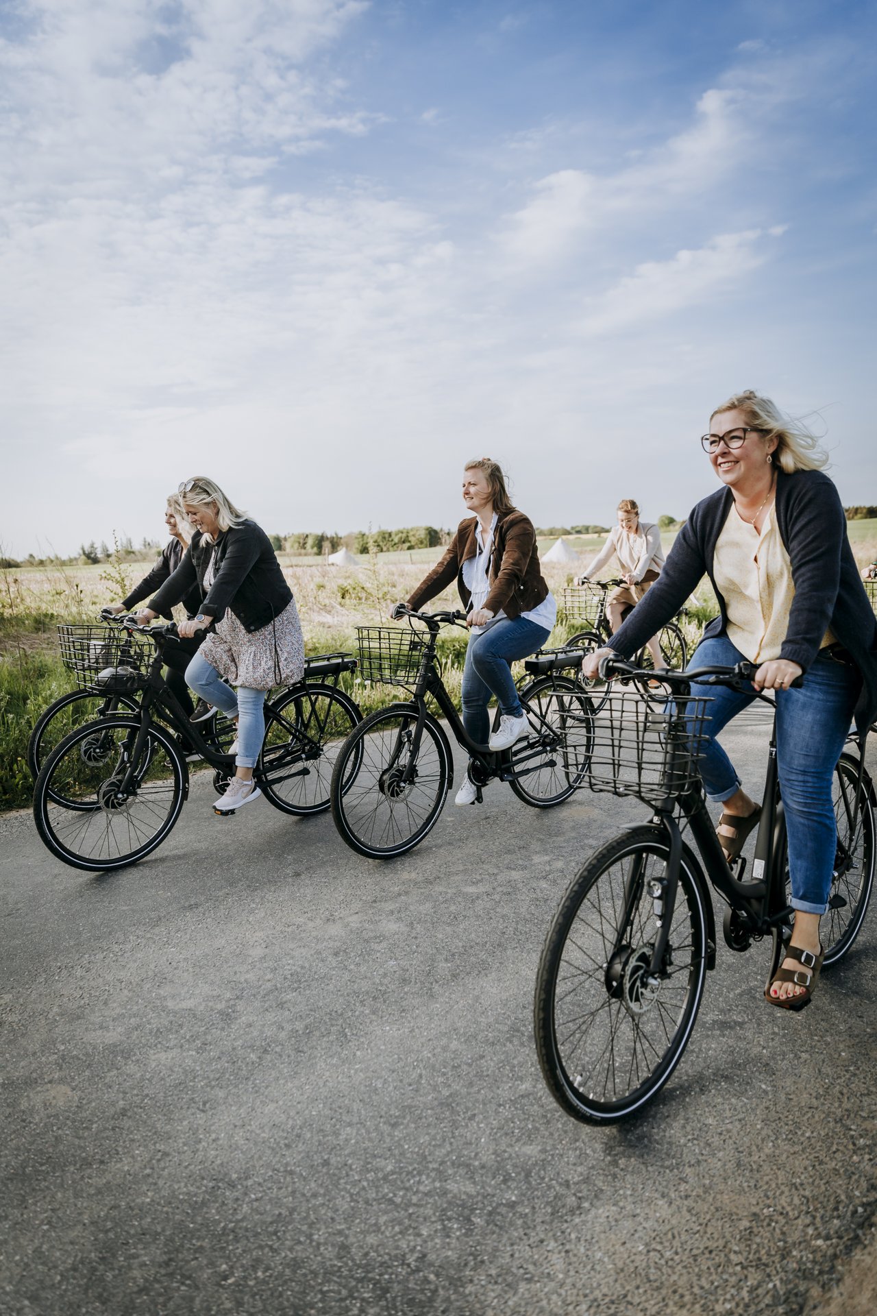 Fire cyklister cykler på en sti i naturen