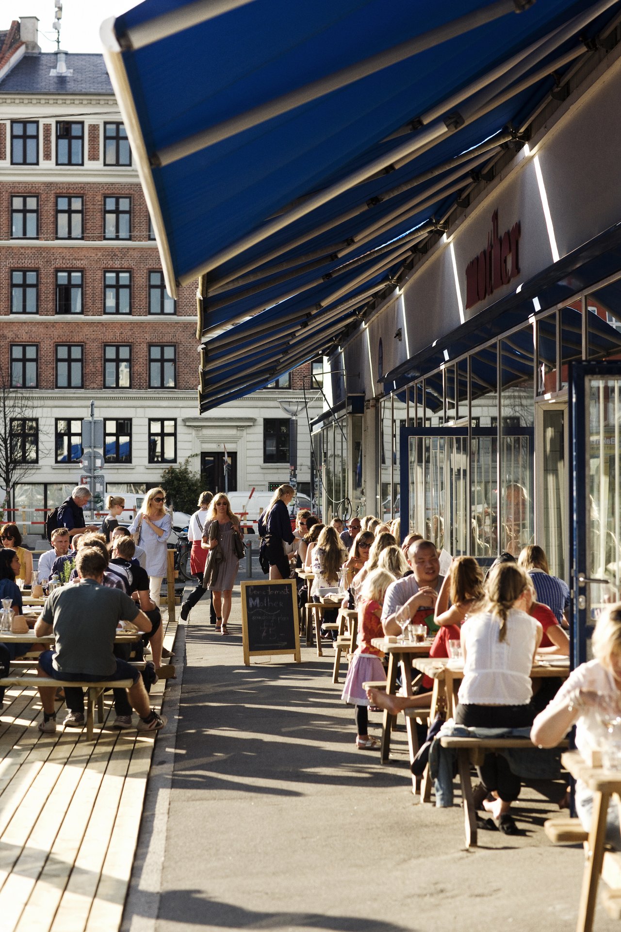 En masse mennesker hygger sig på en cafe i Kødbyen.
