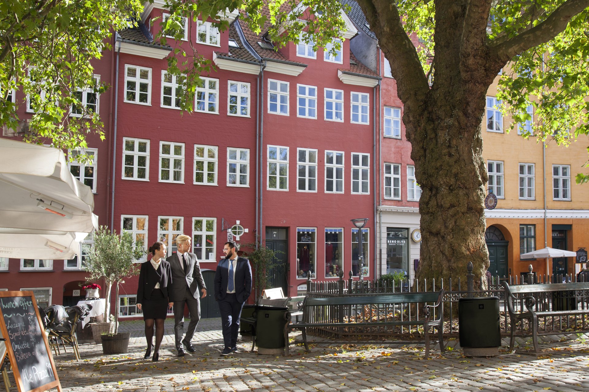 Tre personer i business tøj går på Gråbrødre Torv