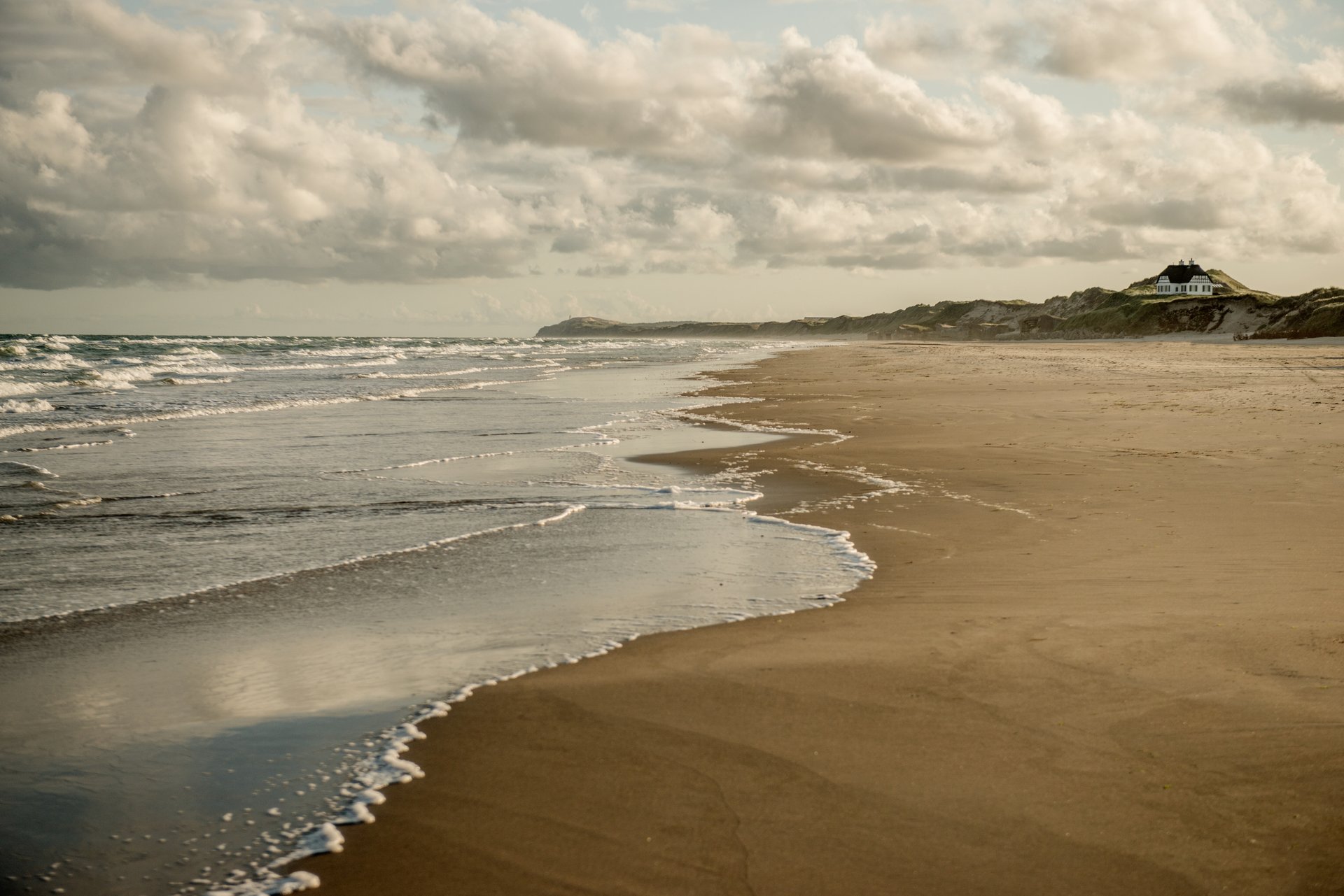 Foto af Løkken strand med en himmel fyldt med skyer