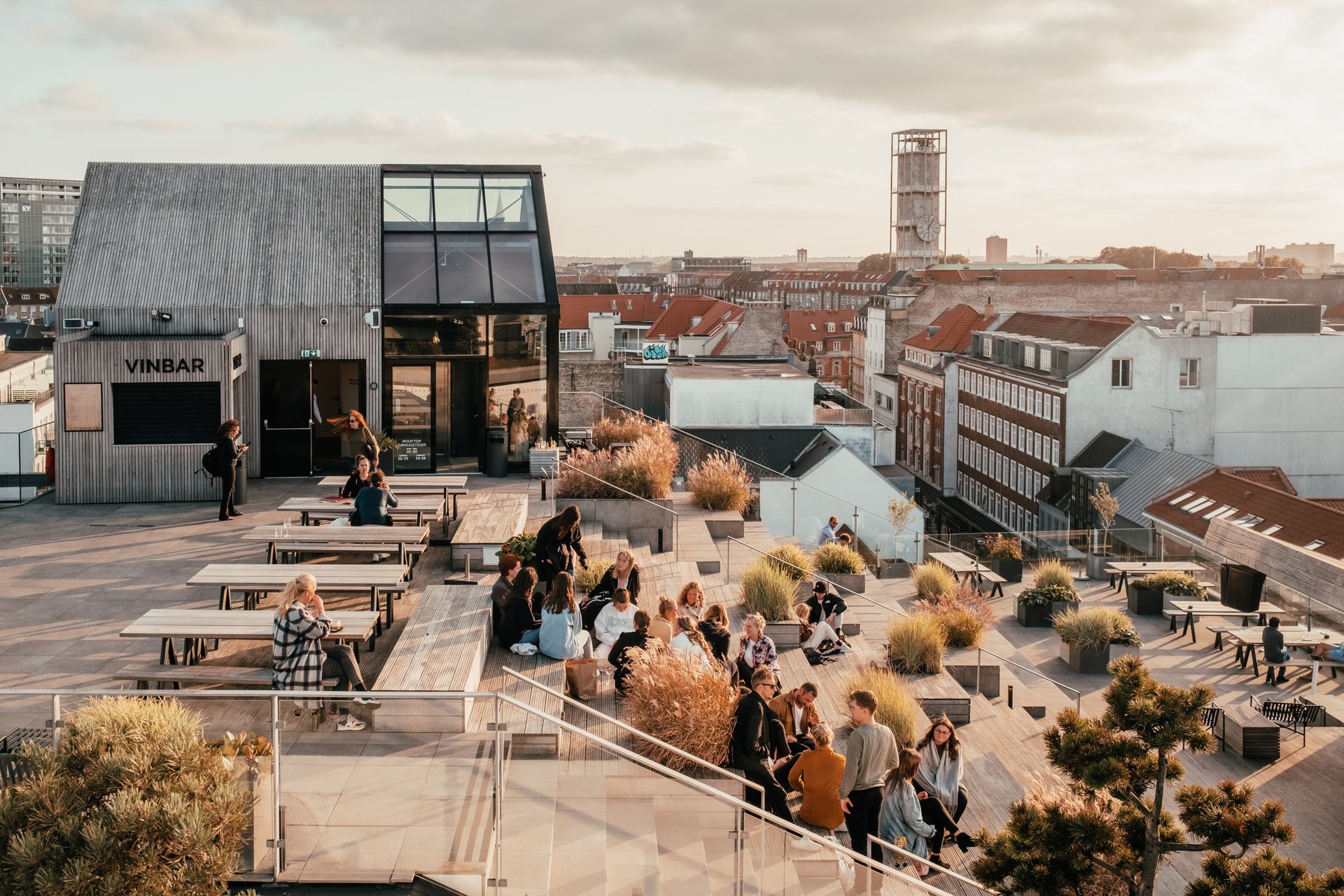 En gruppe mennesker sidder på toppen af Salling Rooftop