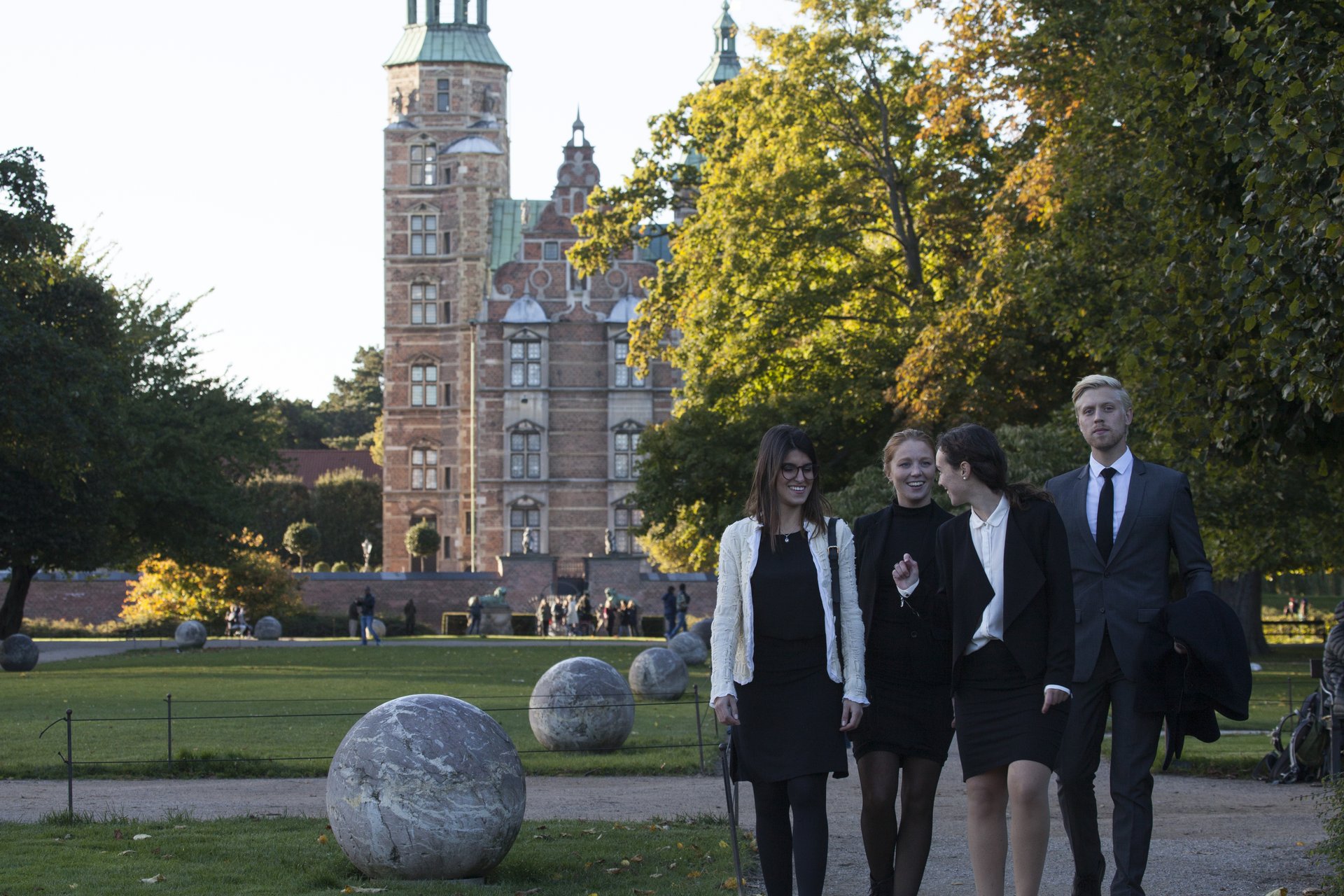 Fire personer i business-tøj går en tur i Kongens Have