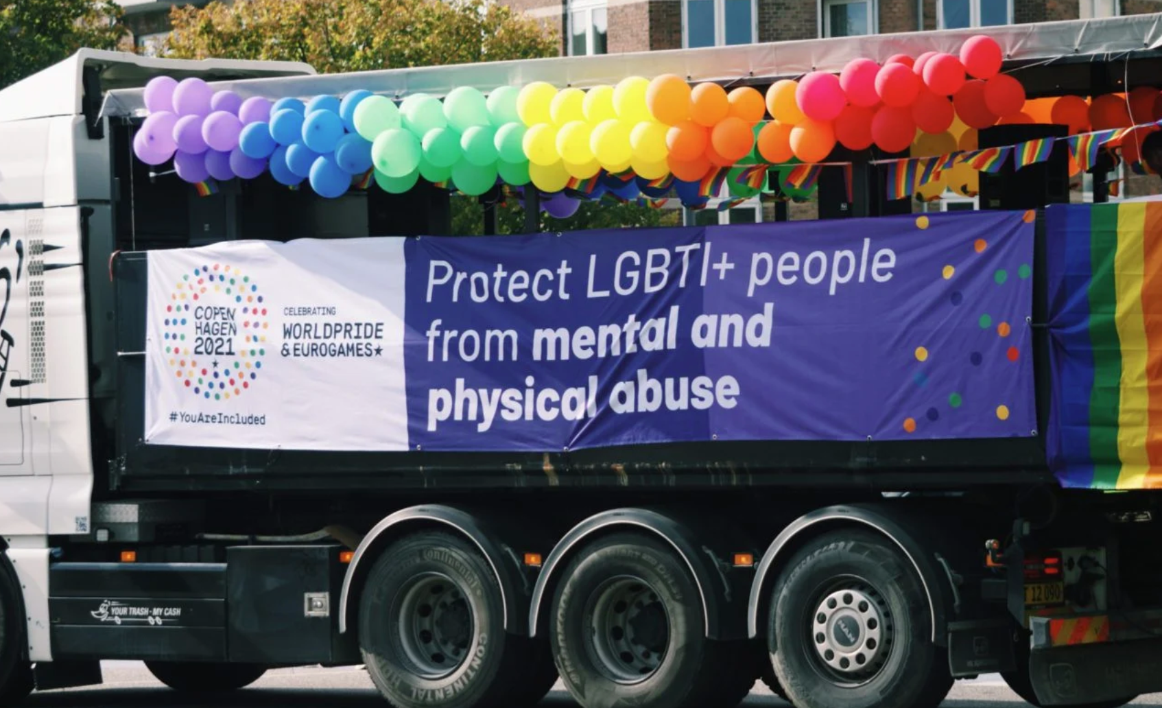 Foto af en lastbil dekoreret med balloner og banner i regnbuens farver til Copenhagen Pride-paraden