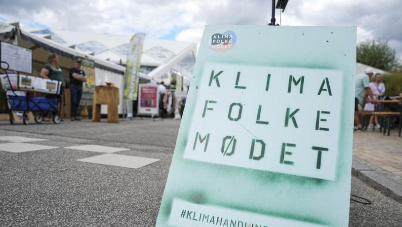 Foto af et skilt på en gade med reklame for Klimafolkemødet