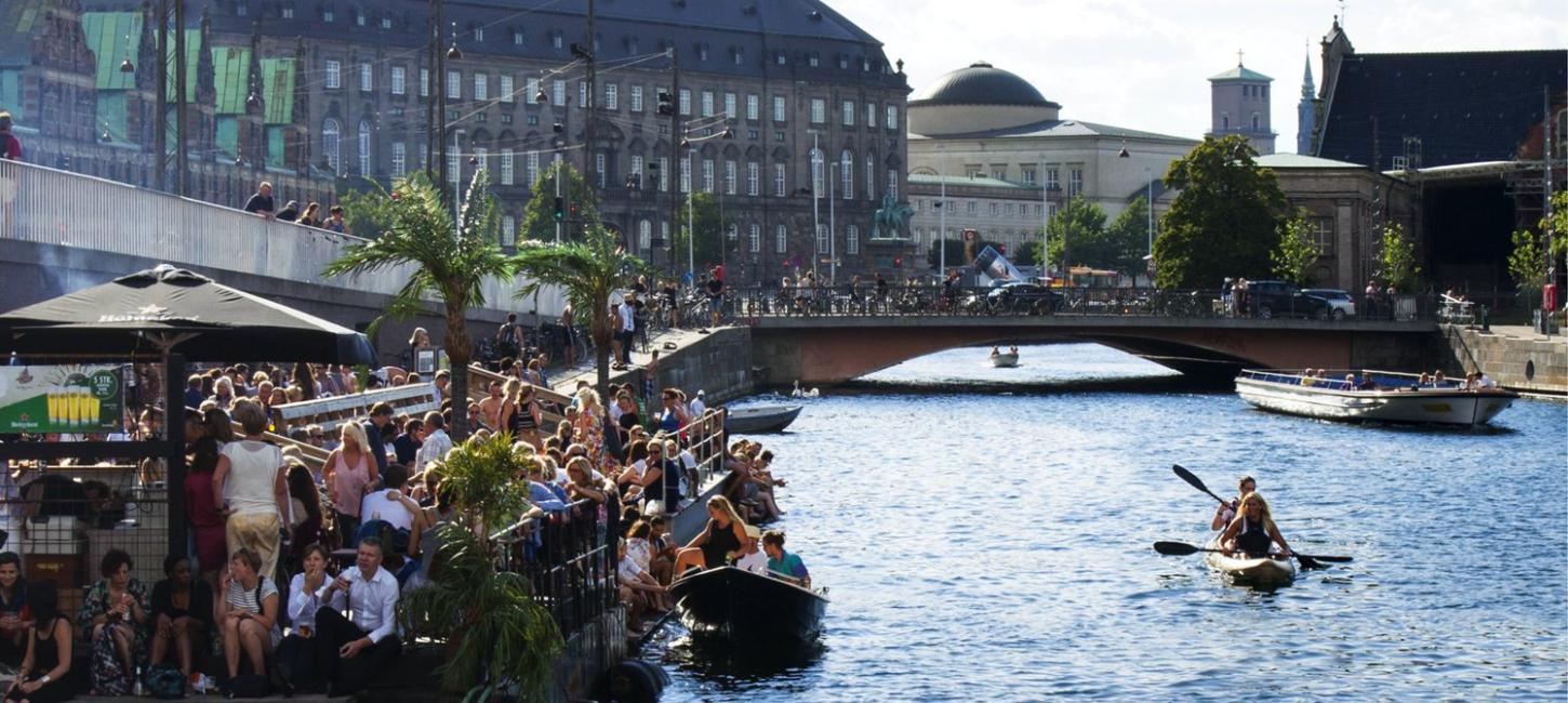 En gruppe mennesker hygger sig ved kanalen ved Christiansborg