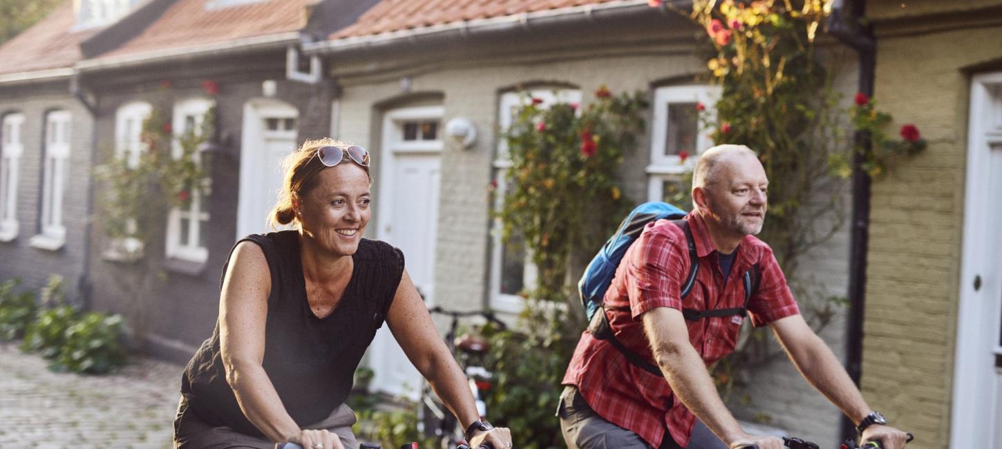 To personer cykler i gadebilledet på Djursland