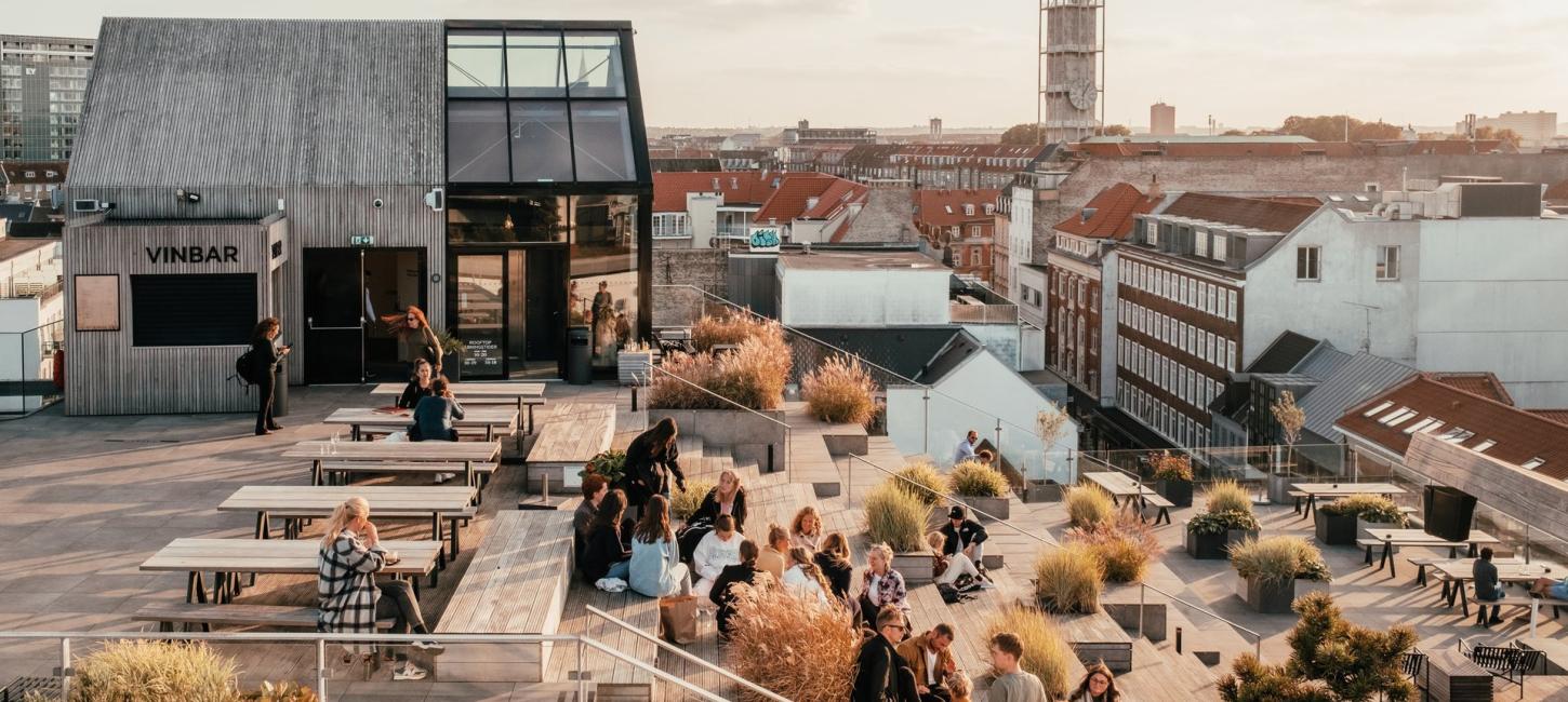En gruppe mennesker sidder på toppen af Salling Rooftop