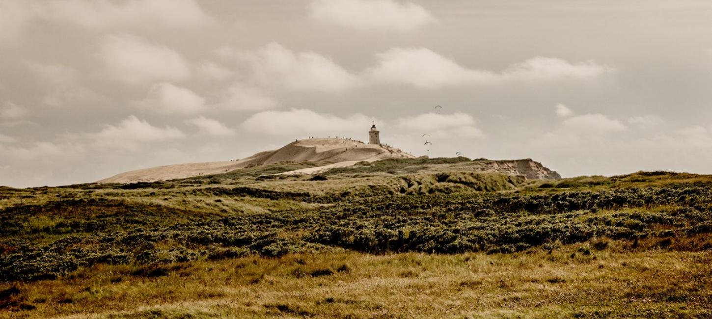 Naturfoto af Råbjerg Knude med fyrtårn i baggrunden