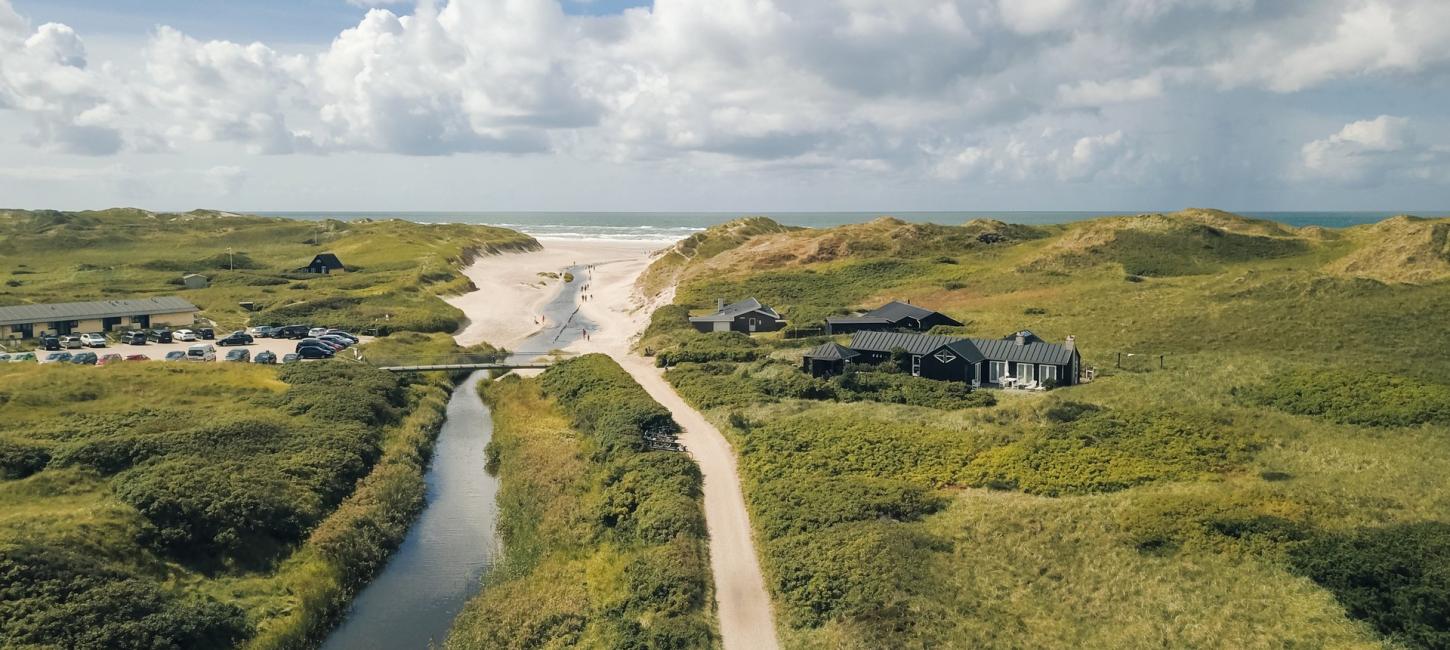 Luftfoto af Henne Strand med sand, hav og et par feriehuse