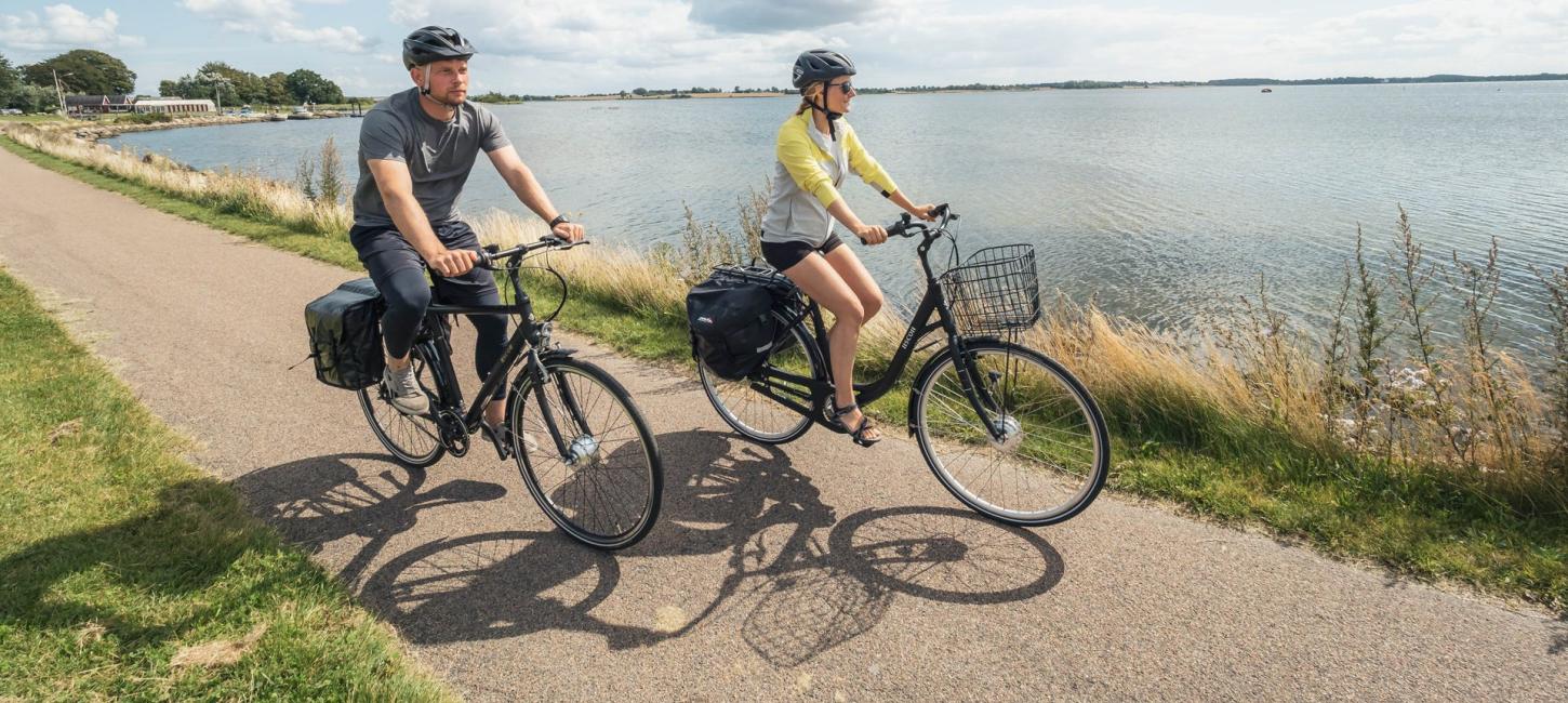 To personer cykler på elcykler