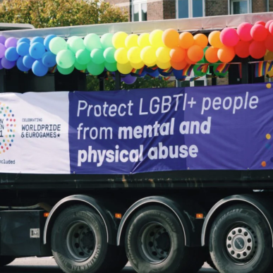 Foto af en lastbil dekoreret med balloner og banner i regnbuens farver til Copenhagen Pride-paraden