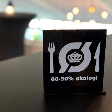 Et skilt med det økologiske spisemærke står på et bord